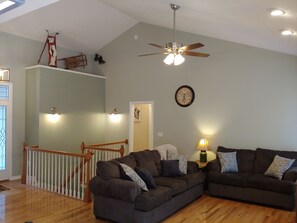 Great room features coach love seat and tv over gas fireplace. 