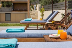 Poolside area with sun loungers and umbrellas for shade.