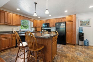 Fully stocked kitchen with dishwasher, full size fridge, microwave, stove and oven