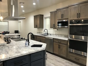 Kitchen with double ovens, microwave, and farmhouse sink w/RO water faucet