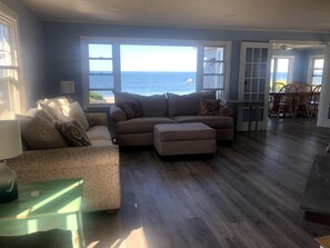 View of living room coming in front door. Looking out to the ocean.