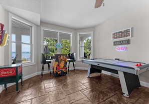 Game room with arcade game, shuffleboard and air hockey.