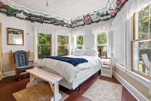 Queen size bed is surrounded by windows
