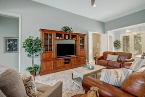 A large flatscreen TV with cable package is in the living area; 2nd guest bedroom is to the right of the wall unit..
