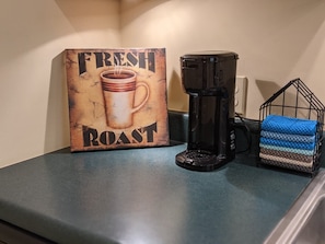 K-cup coffee maker w/ a variety of kcups, sweetners, creamers, & mugs provided