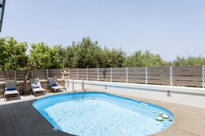 swimming pool with sunbeds during the day