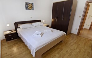The bedroom with double bed, bedside tables with night lamps, wardrobe.