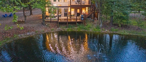 view of the back of cabin on the pond