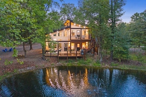 view of the back of cabin on the pond