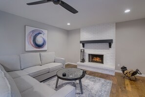 Living room with 60" ROKU TV and wood burning fireplace.