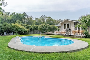 Private and fenced-in, with a tree-lined backdrop that creates a mesmerizing symphony on a windy day—perfect for relaxing on a float.