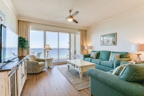 Living Room | Breathe Easy Rentals - Living room furnished with beautiful emerald colors and coastal decor and plenty of seating for everyone.