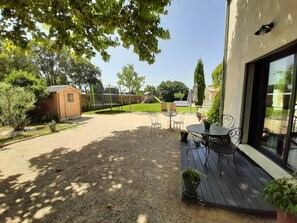 Vue extérieure jardin, trampoline et petite terrasse en composite