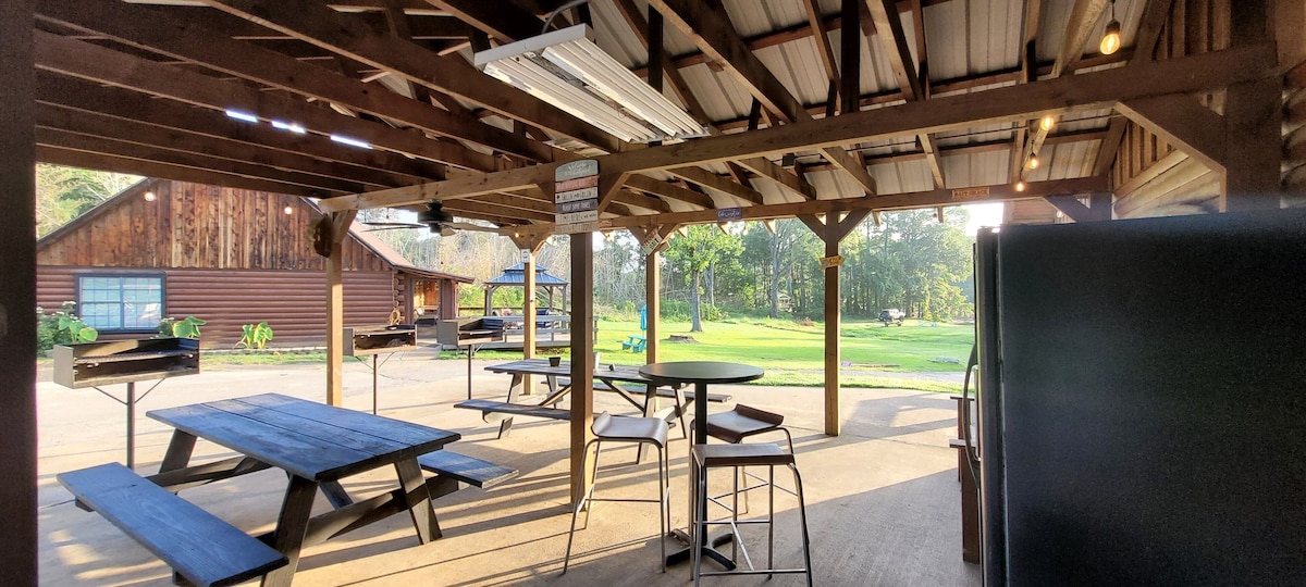 Pavilion next to lodge with additional grills, refrigerator, outdoor seating
