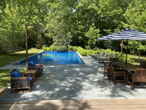 Custom landscaped and thoughtfully furnished backyard with heated saltwater pool