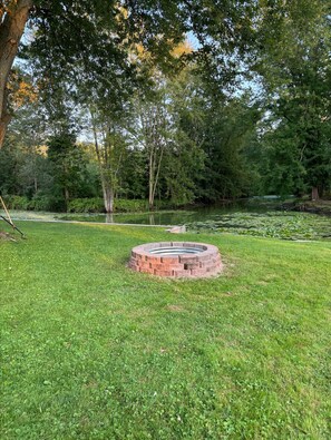 Firepit and view of woods across the channel. Easy to launch kayaks from yard.
