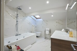 Gorgeous en-suite marble bathroom with jet bathtub.