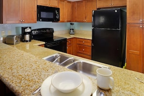 Fully equipped kitchen with a microwave, stove, oven and fridge. All utensils, plates and glasses are provided
