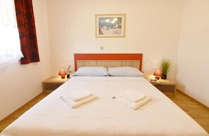 Bedroom 1 with double bed, two bedside tables with night lamps.