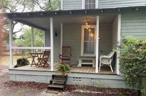 Side porch with cafe table, rocker and settee.  