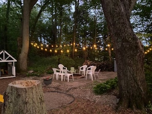 A firepit complete with lights, landscaping, and firewood