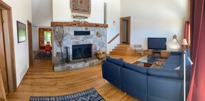 Living room looking at field stone fireplace with steps leading to bedrooms 2+3.