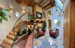 Living room with curving stair case up to the loft and office spaces