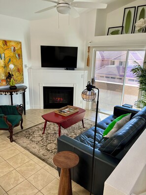 Living room with electric fireplace and balcony access