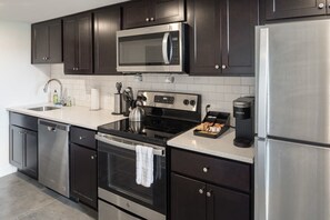 Enjoy home-cooked or the neighborhood's best takeout in this lovely kitchen with stainless steel appliances, a microwave, and a full-sized refrigerator