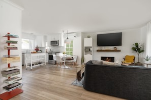 Great room with working fireplace and 72" HD Smart TV.