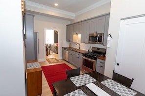 A luxuary kitchen, with plenty of cabinets and cooking prep space. Large 6 burner stove, coffee station, and smaller table.