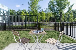 An outdoor space with a green lawn, deck chairs, and a fence, providing a peaceful area for relaxation.
