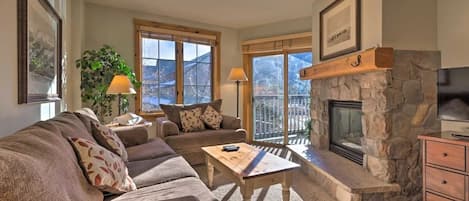 Cozy Living Room space with gas fireplace, pullout bed, and sliding glass door to a furnished patio overlooking the mountain!