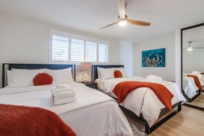 New queen beds and mattresses occupy the single bedroom. Plantation shutters, ceiling fan, small dresser and large mirrored closet