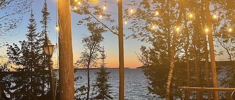 Upper firepit with globe lights and view of georgian bay. 