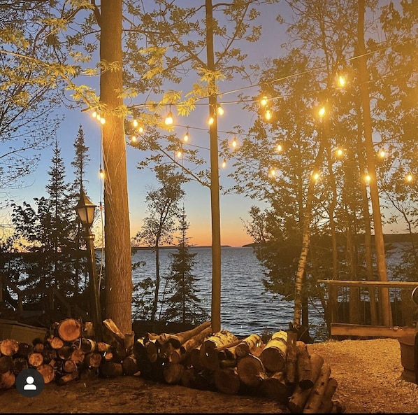 Upper firepit with globe lights and view of georgian bay. 