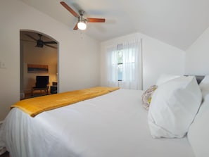 The king-size bed has quality linens and outlets in each bed stand.