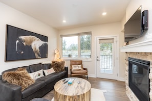 Living area featuring flat screen TV, sleeper sofa, gas fireplace, and balcony attached.