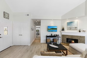 Living room with gas fireplace, cable TV, and balcony access