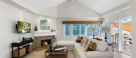 Living room with gas fireplace, cable TV, and balcony access