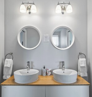 Guest bathroom with hairdryer, makeup remover wipes, and bath towels. 