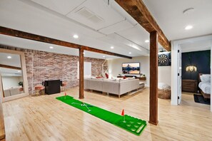Our downstairs living area offers something for everyone — from golf enthusiasts to arcade gamers.