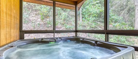 Hot tub on the screened in porch facing the woods with sounds of a creek nearby 