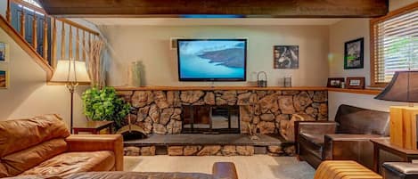 Family room downstair with wood burning fireplace, roku tv and foosball 