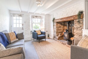 Salty's Cottage, St Agnes. Ground floor: Sitting room with comfortable seating, a wood burning stove and Smart television