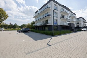 The exterior of a modern residential building with a clean parking lot and well-maintained surroundings.