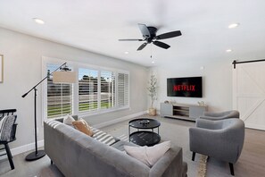 Bright, spacious living room with adjacent game room