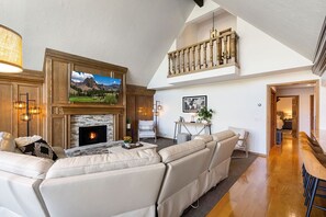 Main floor living room with gas fireplace and large smart TV.