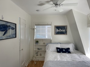 Cute bedroom with fan and tv.  