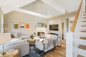 Light and bright living space with new wood flooring and vaulted ceilings